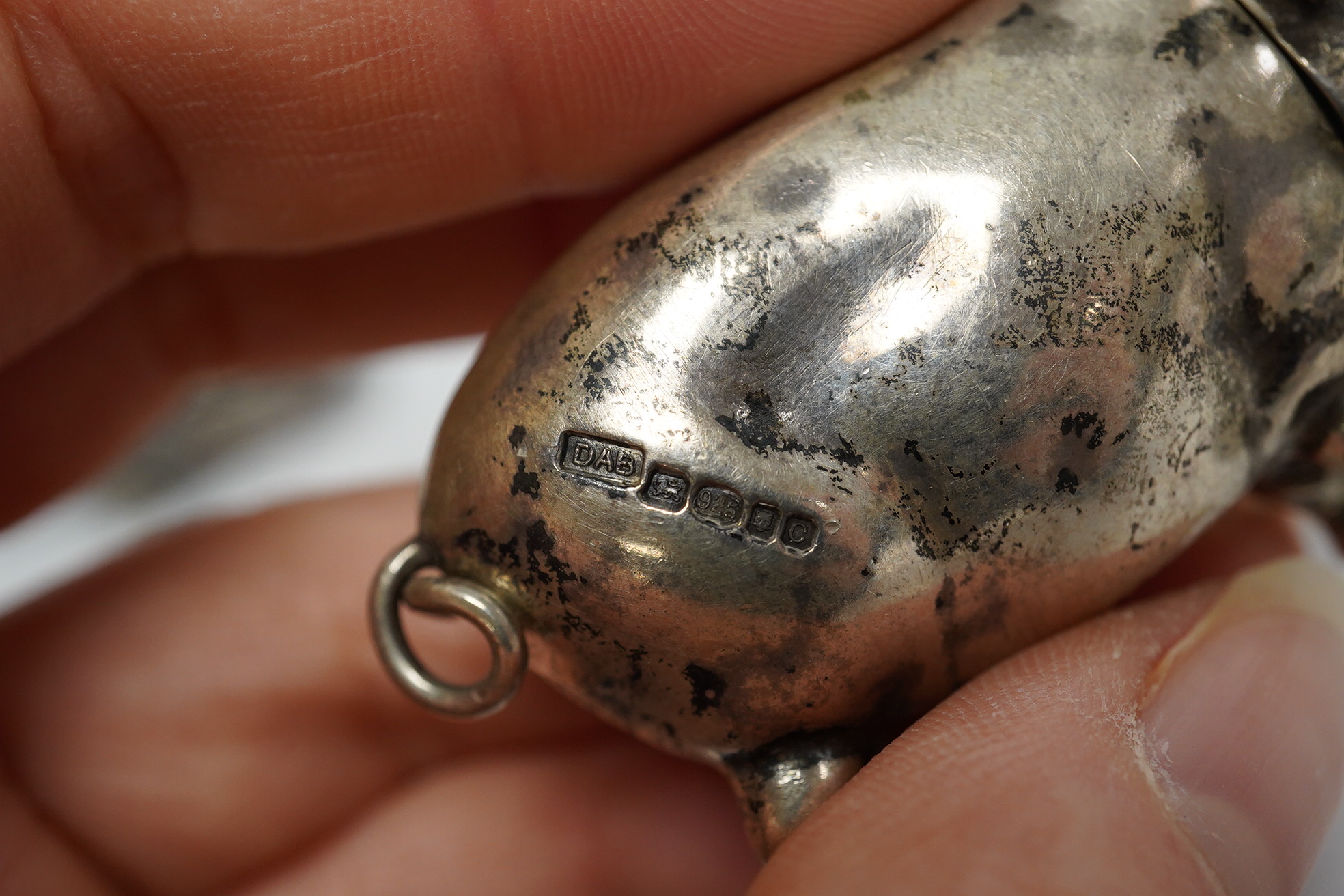 A modern silver novelty vesta case modelled as a pig, by David A. Bowles, London, 1902, 62mm, together with a novelty sterling whistle modelled as a dog's head. Condition - fair to good